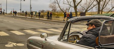 PARIS, FRANCE, JANUARY - 2020 - Dönüş perspektifli adam Paris Bulvarı 'nda üstü açık klasik araba kullanıyor.