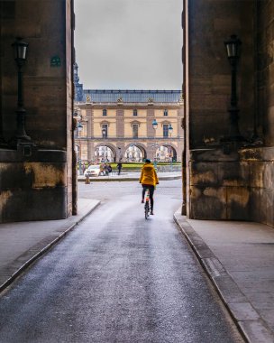 Louvre Müzesi 'nin duvarlarında bisiklete binen kişi, Paris, Fransa