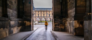 Louvre Müzesi 'nin duvarlarında bisiklete binen kişi, Paris, Fransa