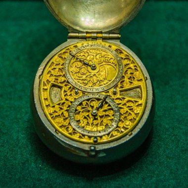 Yüksek açı, yeşil arka plandaki antika altın lüks saati vurdu.