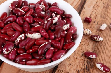 Ahşap arka planda izole edilmiş kırmızı fasulyeler.