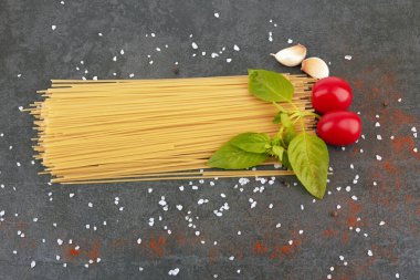 fesleğenli siyah bir arka planda spagetti.
