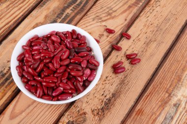 Ahşap arka planda izole edilmiş kırmızı fasulyeler.