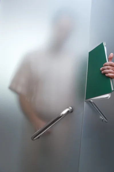 Hombre de negocios caminando a través de la puerta de cristal — Foto de Stock