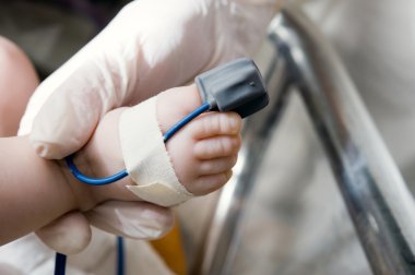 Pulse oximeter sensor on a baby clipart