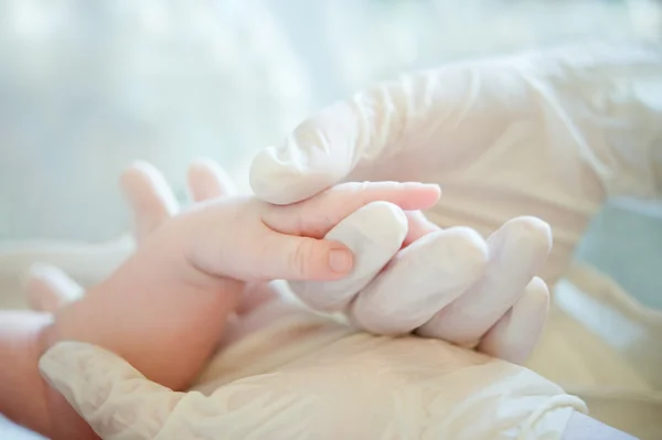 Eine helfende Hand für kleines Baby im Krankenhaus Stockbild