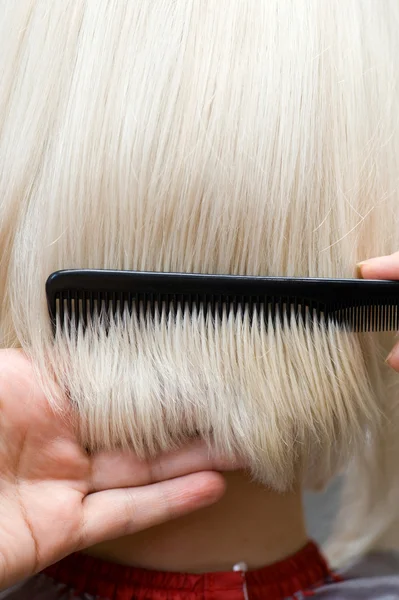 Парикмахер расчесывает волосы — стоковое фото