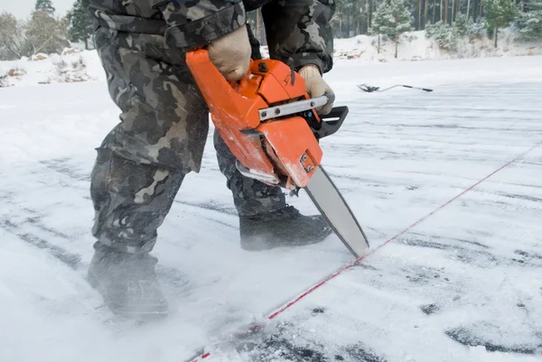 Lavoratore ritagliarsi del ghiaccio sul lago — Foto Stock