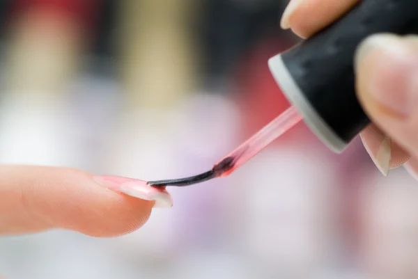 Mujer aplicando esmalte de uñas rosa Imagen De Stock