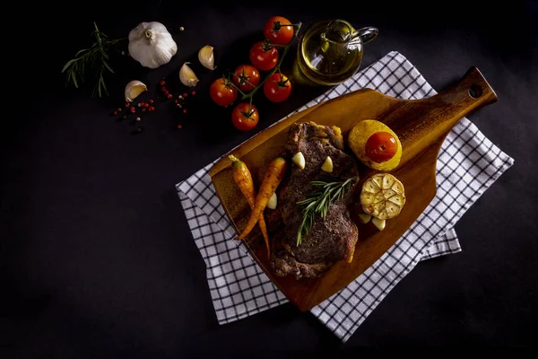 Rundvlees Biefstuk Een Houten Snijplank Met Groenten Specerijen Zwarte Achtergrond Stockafbeelding