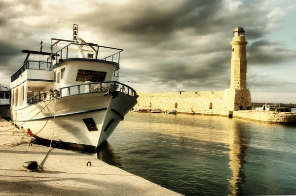 Lighthouse and boat in old port of Rethimno- artistic toned picture — Stock Photo, Image