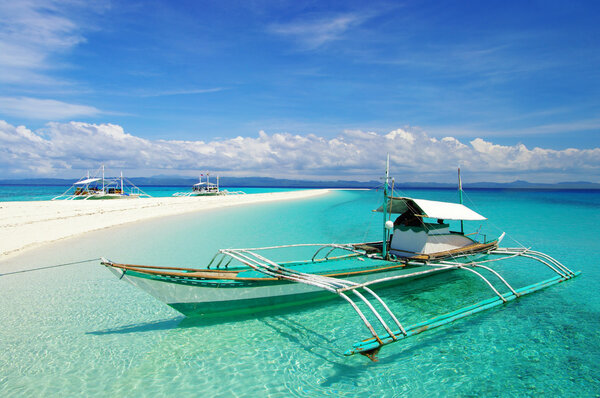 Тропическая сцена на пляже с лодкой
