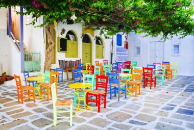 Sokaklardaki geleneksel Yunan meyhaneleri. Ios Adası, eski Chora kasabası. Renkli, tipik sandalyeleri olan bir restoran. Cyclades, Yunanistan