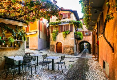 İtalyan köylerinin dar sokaklarını büyülüyor. Malcesine, Garda Gölü, İtalya. Sonbahar renkleri, rahat sokak barları