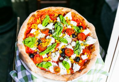 İtalya 'yı gezmek, İtalyan kültürünün bir parçası - sağlıklı Akdeniz yemekleri. Roma sokak restoranları ve pizzacılar. Mozarella, bazilika ve domatesli taze pizza.