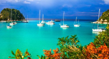 Paxos, Yunanistan 'ın İyon adaları. Lakka' da güzel bir turkuaz koy. Yelkenli teknelerle manzara. Yunan yaz tatili