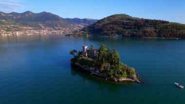 Amazing lake Iseo scenery with picturesque small island Loreto with castle, aerial drone view. Italy, Brescia province