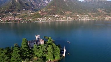 Amazing lake Iseo scenery with picturesque small island Loreto with castle, aerial drone view. Italy, Brescia province