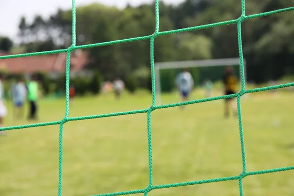 Groene voetbal netto, groen gras — Stockfoto