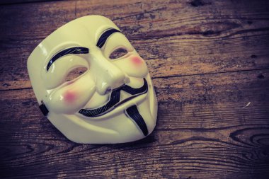 Anonymous mask on wood background