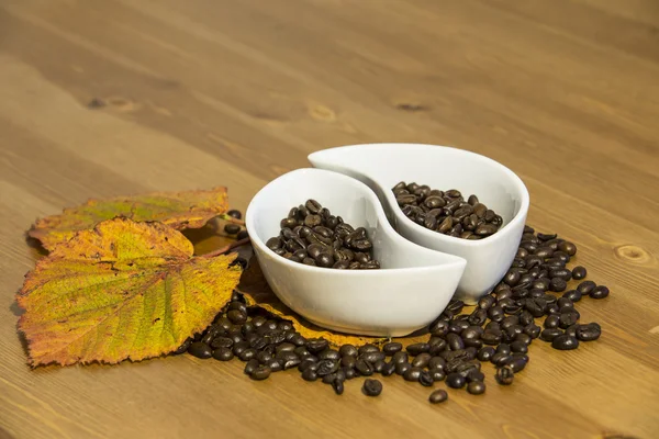 Tazas con granos de café en una mesa de madera — Foto de Stock