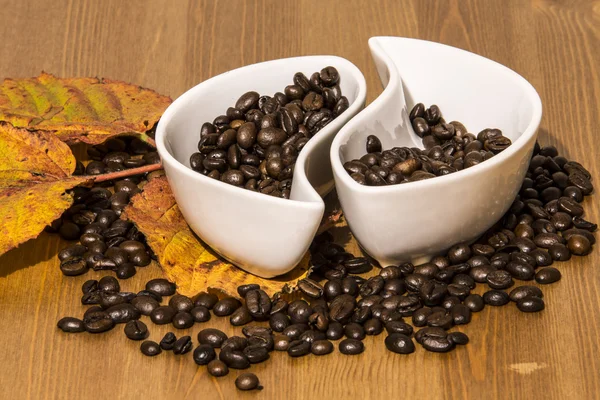 Tassen mit Kaffeebohnen auf einem Holztisch — Stockfoto