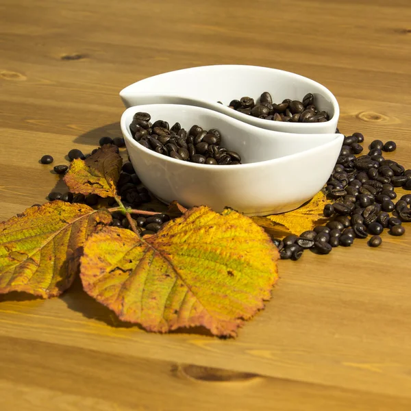 Cups met koffiebonen op een houten tafel — Stockfoto