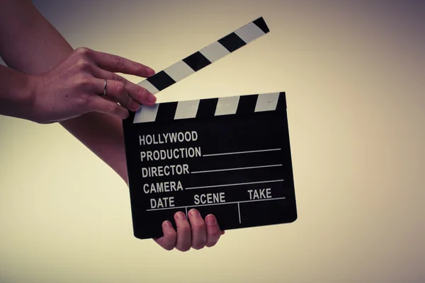 Movie flapper in womans hands on white background — Stock Photo, Image