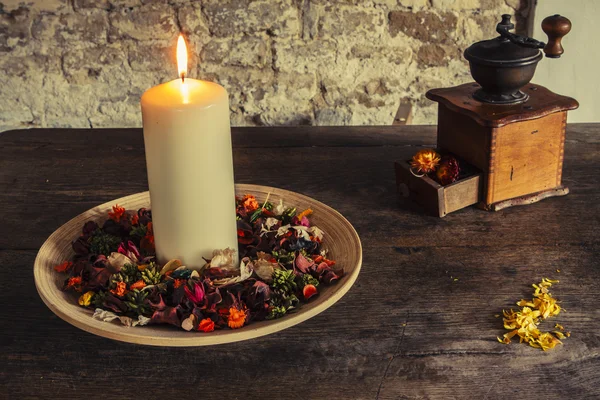 Candle on the wooden plate with coffee mill — Stock Photo, Image