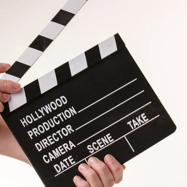 Movie flapper in womans hands on white background — Stock Photo, Image