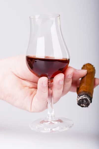 Gamla brandy i glas och cigarr i manlig hand på vit bakgrund — Stockfoto