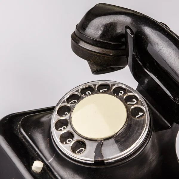 Teléfono negro viejo con polvo y arañazos sobre fondo blanco — Foto de Stock