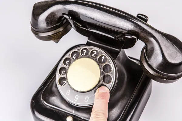 Velho telefone preto com poeira e arranhões no fundo branco — Fotografia de Stock