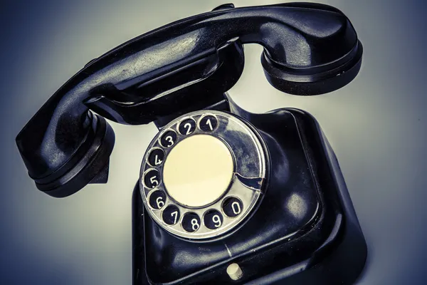 Old black phone with dust and scratches on white background — Stock Photo, Image