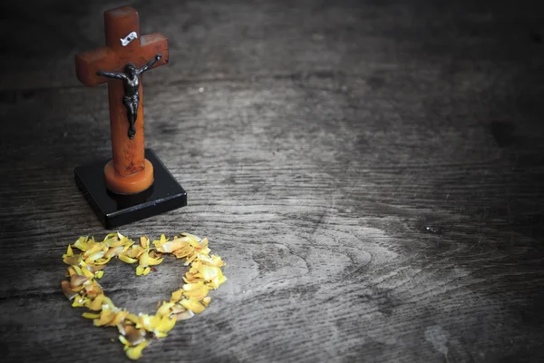 Hermosa cruz vieja con Jesús y corazón de hojas en el viejo suelo de madera — Foto de Stock
