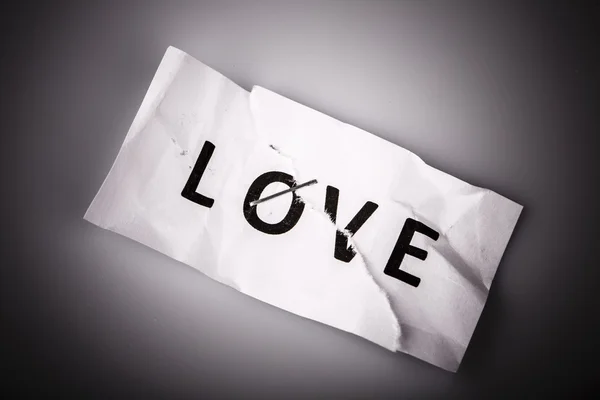 "Aşk" kelimesi yırtık ve zımbalanmış kağıda yazılmış — Stok fotoğraf