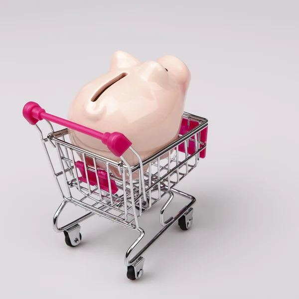 Pig money box in shopping cart on white background — Stock Photo, Image