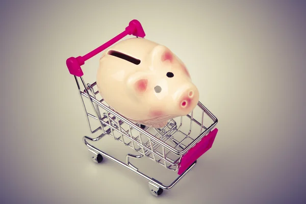 Pig money box in shopping cart on white background — Stock Photo, Image