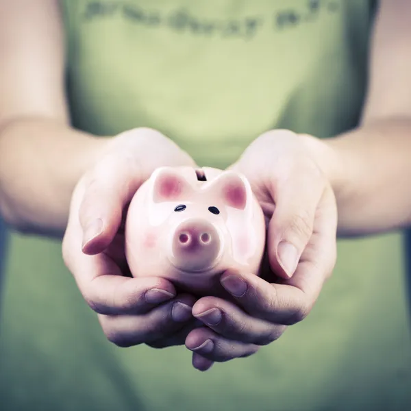 Caja de dinero de cerdo en mano de mujer —  Fotos de Stock