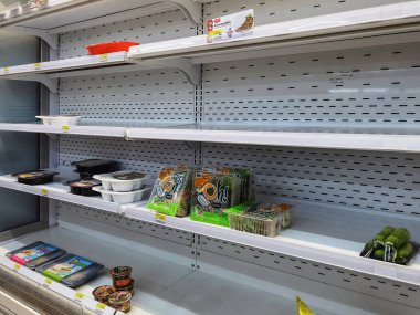 KANCHANABURI, THAILAND-AĞUSTOS 14. 2021: 7-Eleven 'deki rafın çoğu boş, koronavirüs (COVID-19) PTT benzin istasyonuna yayılırken panik satın alma sürecinde sadece birkaç paket yiyecek kaldı..