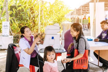 KANCHANABURI THAILAND - 14 ARALIK: 14 Aralık 2019 tarihinde Kanchanaburi, Tayland 'da halk parkındaki göz muayenesi hizmetleri için mobil bir hastane birimi.