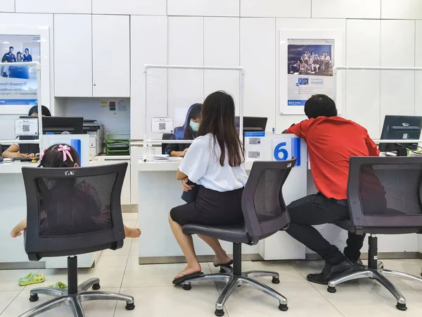 KANCHANABURI, THAILAND - 27 AĞUSTOS 2020: TMB Bank Public Company Limited 'de Coronavirus (Covid-19) sırasında banka personeliyle tanımlanamayan Asyalı kadın müşteri alışverişi. Yeni Normal Yaşam Tarzı.