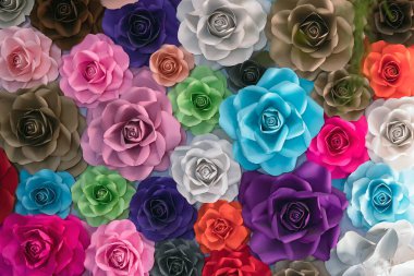 Rose kağıttan yapılmış. El yapımı güller. Renkli origami güllerinin toplanması güzel bir çiçek deseni oluşturur. Yapay renkli çiçekli kağıt arka plan. Kağıt işçiliği.