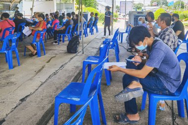 KANCHANABURI, THAILAND-AĞUSTOS 25. 2021: Kimliği belirsiz kişiler Tayland 'ın aşı süreci boyunca tüm yetişkinlere ilk doz COVILO (Sinopharm) Coronavirus aşısı için kuyrukta bekliyorlar.