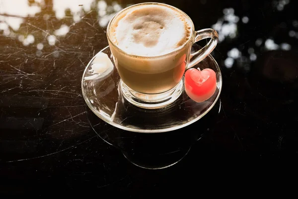 하트는 코걸이에 카푸치노 커피를 곁들인 양초를 만들었습니다 테이블에 심장의 형태로 — 스톡 사진
