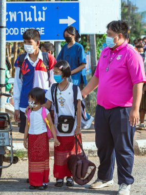 KANCHANABURI, THAILAND-JANUARY 14. 2022: Okuldan eve dönerken Corona virüsünü (COVID-19) önlemek için beş farklı milletten (Tayland, Lao, Mon, Karen ve Birmanya) öğrenciler maske takıyor.