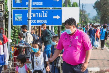 KANCHANABURI, THAILAND-JANUARY 14. 2022: Okuldan eve dönerken Corona virüsünü (COVID-19) önlemek için beş farklı milletten (Tayland, Lao, Mon, Karen ve Birmanya) öğrenciler maske takıyor.