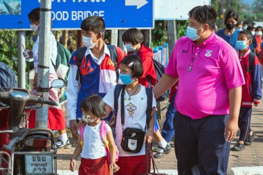 KANCHANABURI, THAILAND-JANUARY 14. 2022: Okuldan eve dönerken Corona virüsünü (COVID-19) önlemek için beş farklı milletten (Tayland, Lao, Mon, Karen ve Birmanya) öğrenciler maske takıyor.