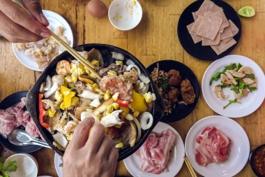 Barbekü Barbeküsü yemek. İnsanlar domuz eti, yemek, kabuklu deniz ürünleri ve karidesleri kızgın siyah tavada pişirecek yağ ve tereyağı ile kızgın fırında kızartıyorlar. Bir restoranda tatil yemeği..