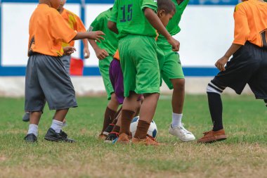 Futbolcu çocuklar antrenman kursu. Bir tarlada futbol oynayan anaokulu öğrencileri. Spor sahasında koşan ve futbol oynayan bir grup çocuk. Futbol maçında çocuklar spor giyer..